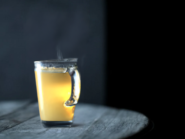 Ein Varm Klem A Clear Glass Cup, Filled With Warm Apple Juice, Cinnamon Stick And Ginger